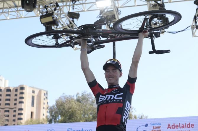 Rohan Dennis (BMC) lofts his bike above his head on the podium