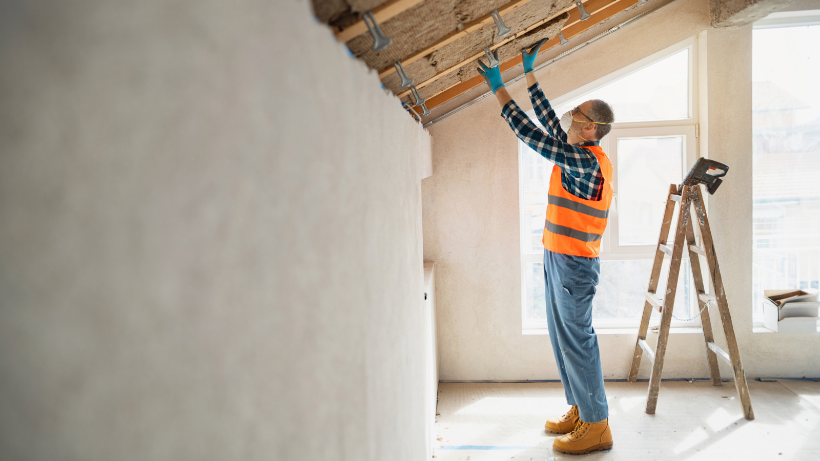 man putting insulation in between battens