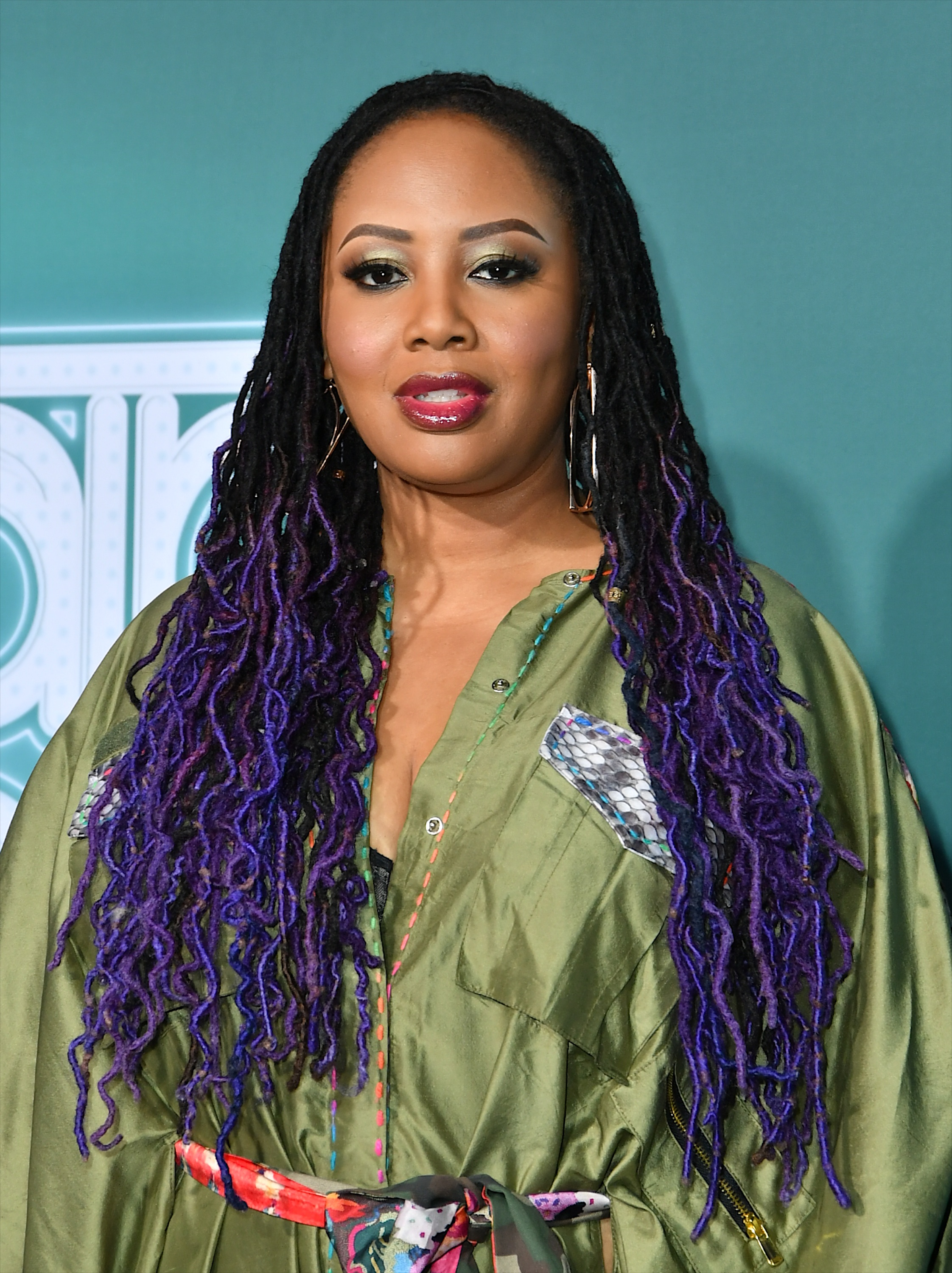 a black woman with long locs that are dyed blue and purple at the ends