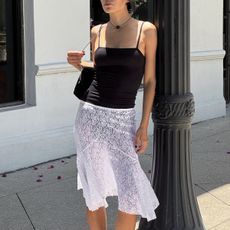 Woman in lace skirt and black cami top