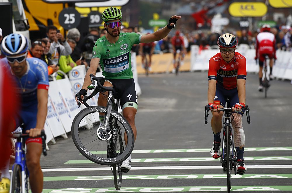 Peter Sagan (Bora-hansgrohe) wheelies over the stage 20 finish line at the Tour de France