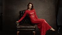 Simone Simons in a red dress draped across a chair