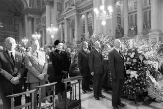 Veterans of the French Resistance stand at attention at the bier of Josephine Baker during funeral services in the Madeleine Church in Paris, as Princess Grace of Monaco (with glasses) stands next to them