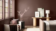 Dark maroon painted living room with wood console and sofa