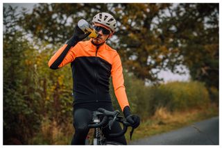 A cyclist takes a drink from his water bottle