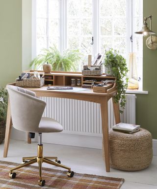 Wooden desk in study area with houseplants and footstool by Dunelm