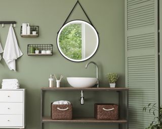 A green bathroom with round bathroom mirror idea