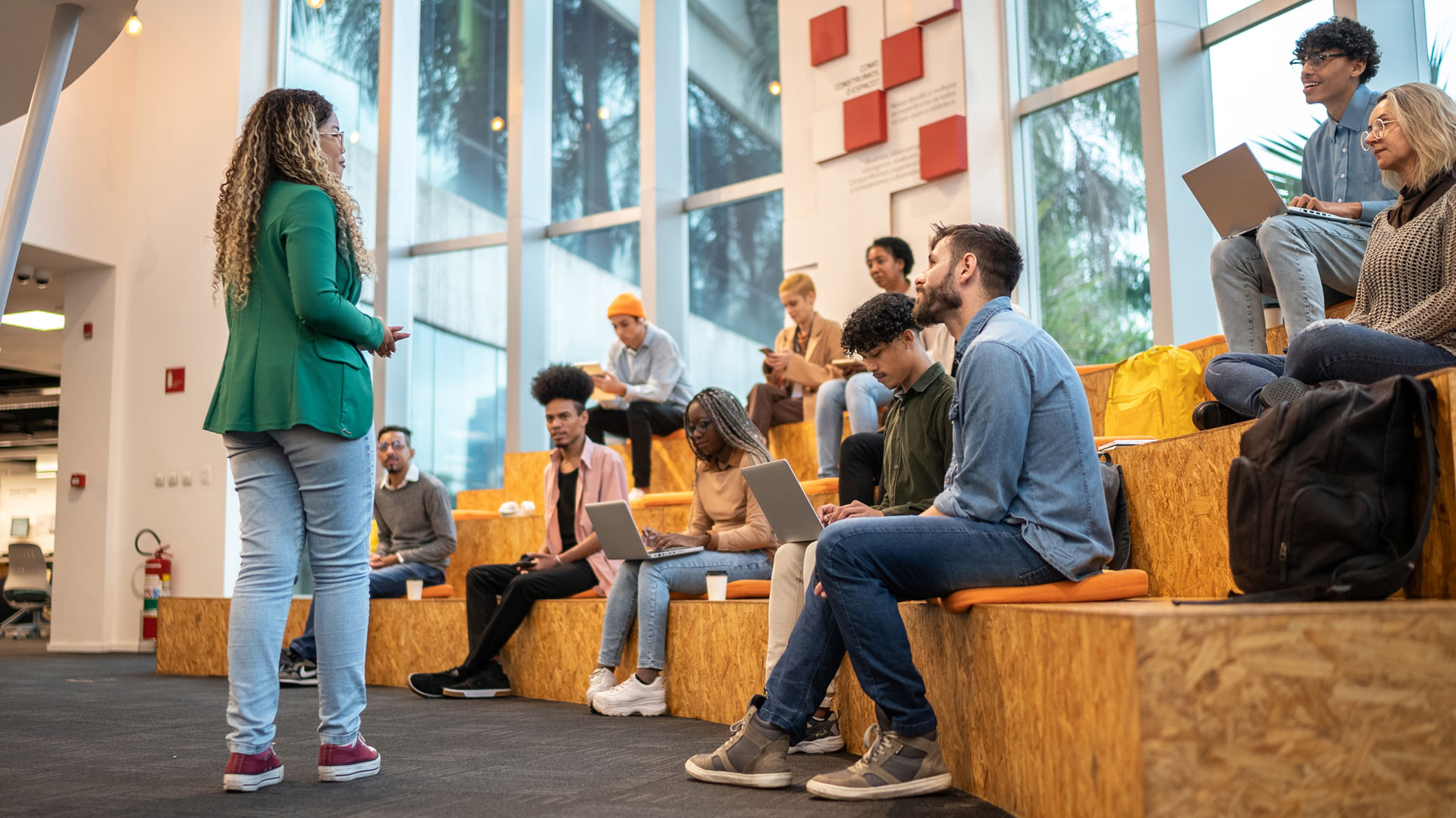 woman talking to a bunch of students who have laptops