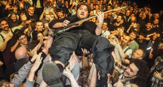 Harry Valentino of Scottish funk-rockers High Fade surfs the crowd and plays guitar during one high-octane show