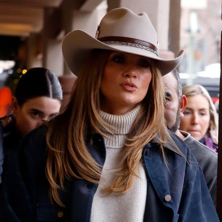 Jennifer Lopez is seen on December 29, 2024 in Aspen, Colorado wearing a cowboy hat, navy blue barn jacket, oat-colored turtleneck sweater, barrel jeans, and lug-sole tan boots.