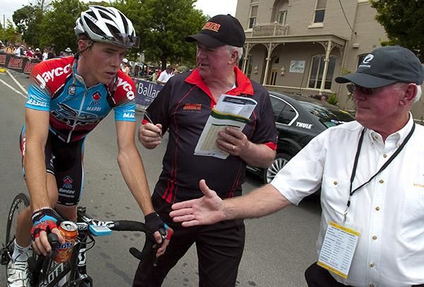 Race winner Rohan Dennis is congratulated by event director John Craven (centre) and commissaire Bill McMahon
