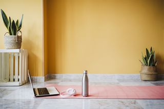 Menopause yoga: a yoga mat, laptop and water bottle
