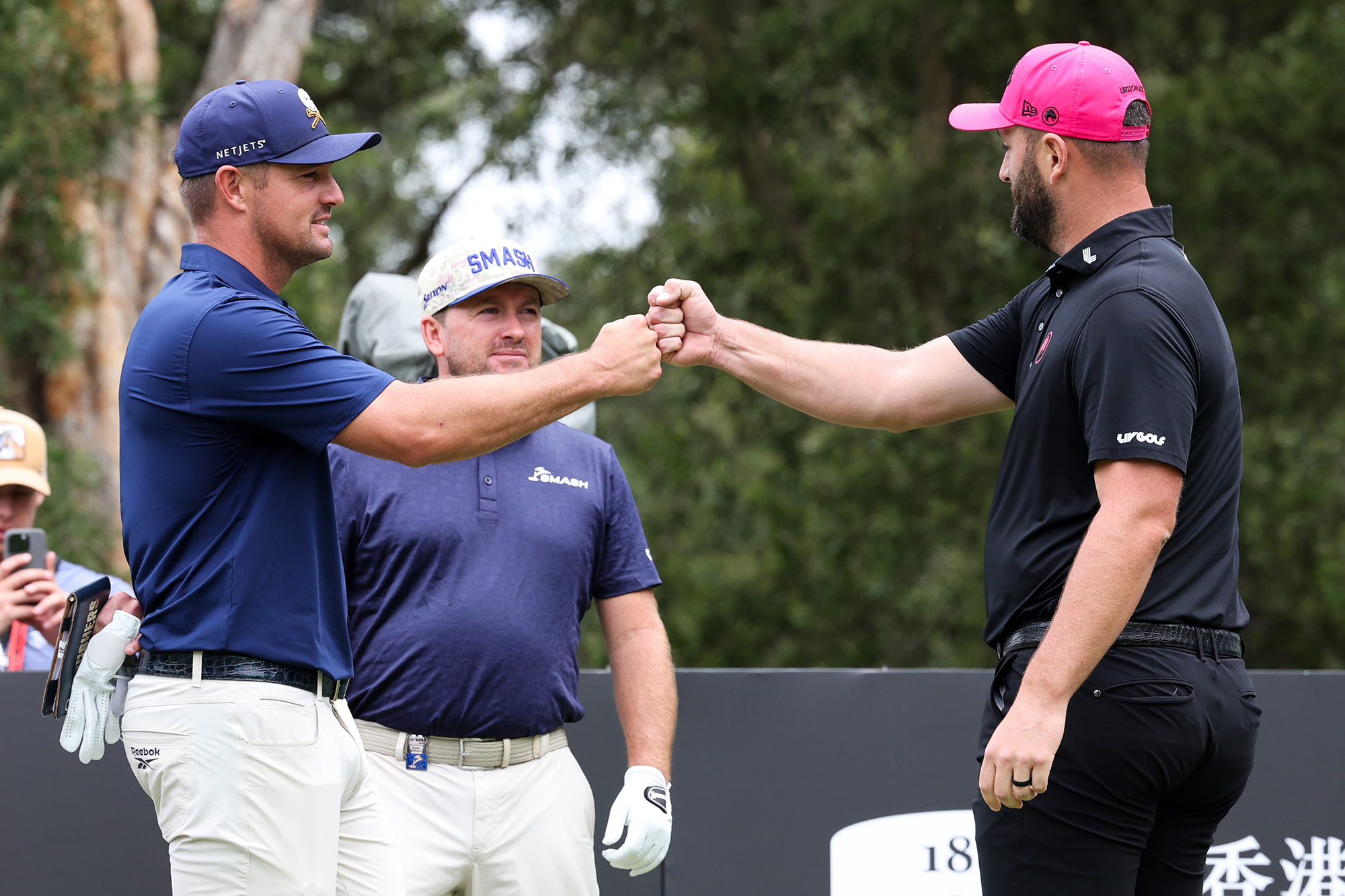 Bryson DeChambeau and Jon Rahm bump fists at a LIV Golf event