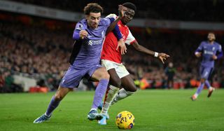 Curtis Jones of Liverpool holds off Bukayo Saka of Arsenal during a Premier League clash