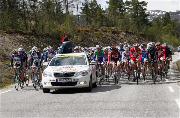 The peloton is still bunched up behind the lead car, waiting for the end of the neutral section.