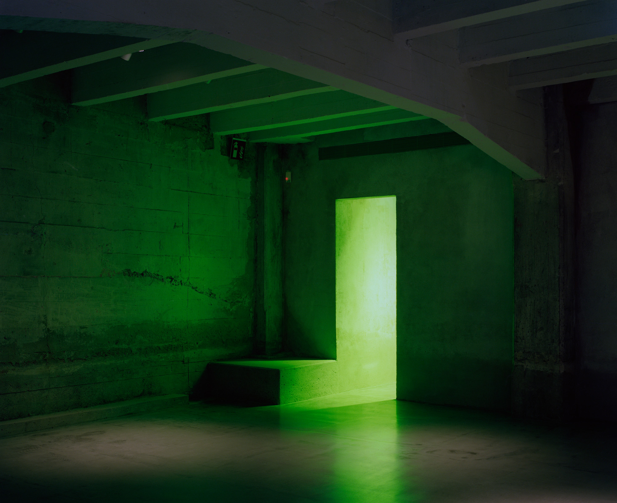 Bare interior of green-lit art space