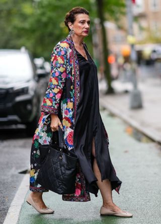 A woman in New York wearing an oversized kimono-style coat over a black slip dress