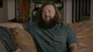 Haley Joel Osment sitting on a couch laughing on Silicon Valley