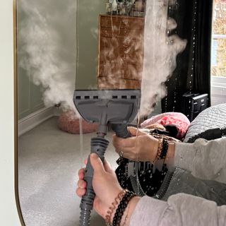 steam cleaning a mirror in a green bedroom