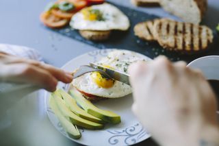 Breakfast with eggs, avocado, bread and tomatoes