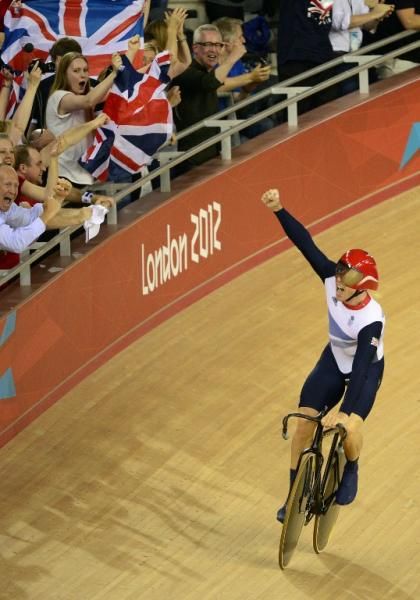 Sir Chris Hoy takes a victory lap after he anchored his Great Britain team to both Olympic gold and a world record in the team sprint.