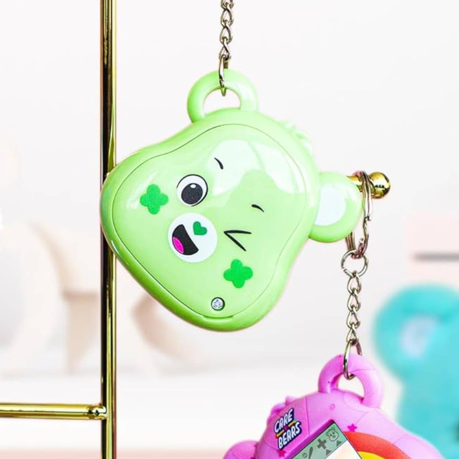 Close up of the Good Luck Bear Care Bears Digital Pet, dangling via a gold chain.