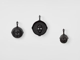 The Cosbys cast iron 3 skillets on wall
