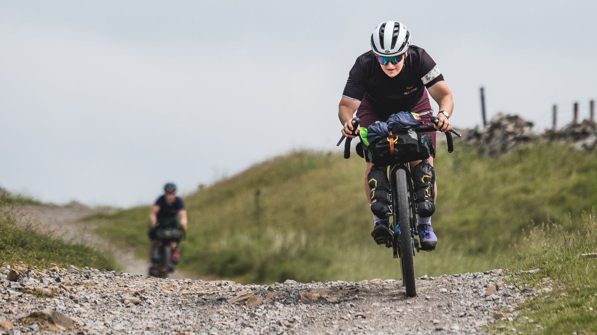 A cyclists descending on a gravel track