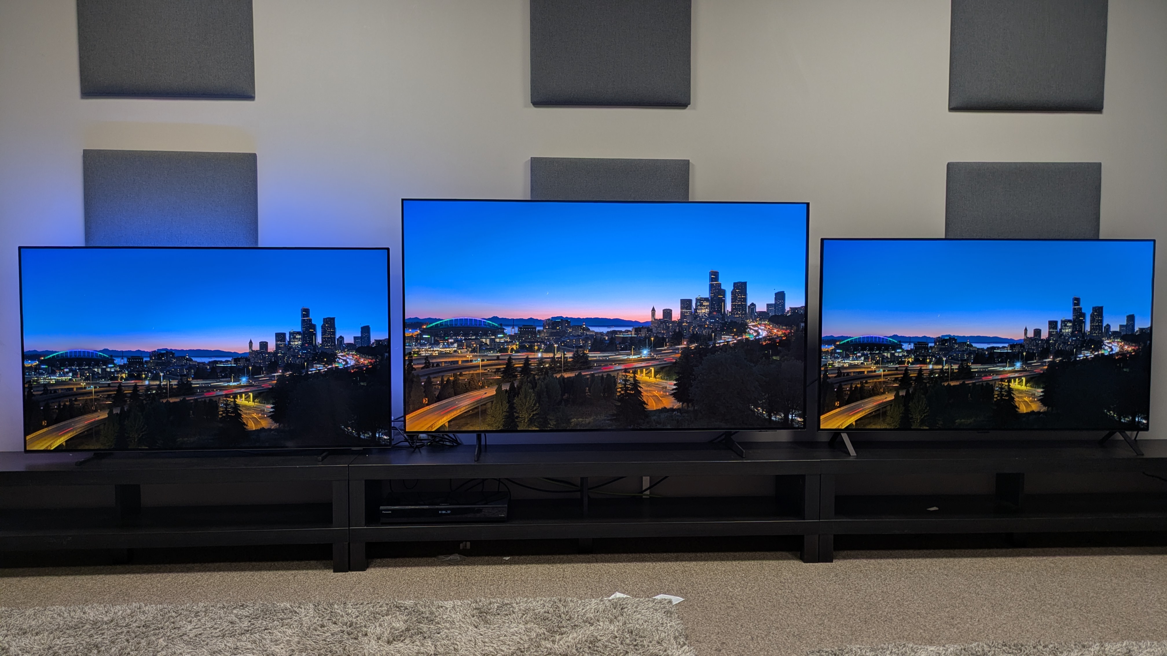 Philips OLED760 vs Samsung S85F vs LG B5 showing a city landscape at dusk on screen 