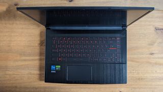 A black MSI GF63 Thin laptop on a wooden desk