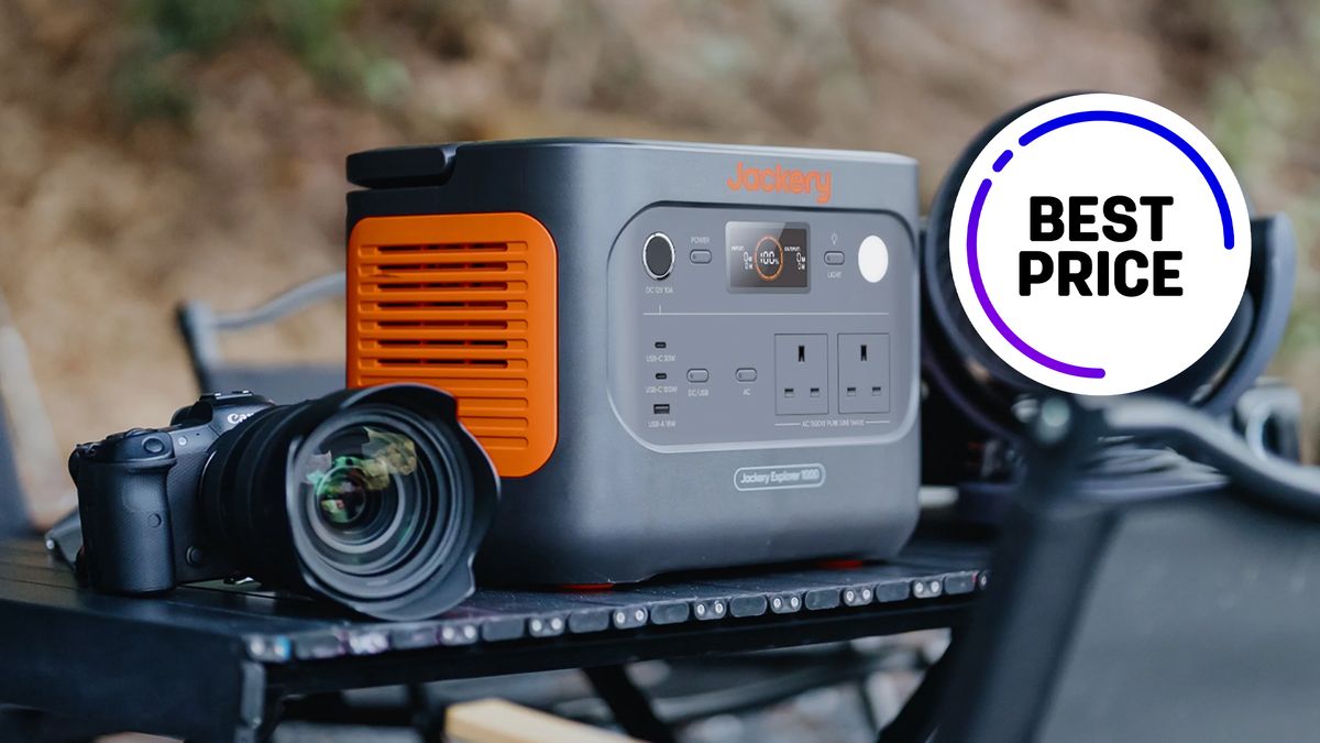 Jackery Explorer 1000 v2, on an outdoor table next to a Canon R System camera, with the text &quot;Best price&quot;