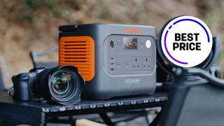 Jackery Explorer 1000 v2, on an outdoor table next to a Canon R System camera, with the text "Best price"