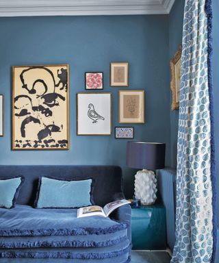 blue living room with blue sofa and gallery wall