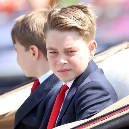 Prince George wears a navy suit and red tie to attend Trooping the Colour 2025