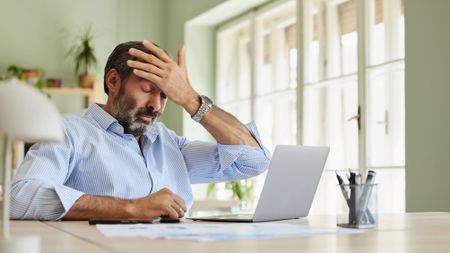 Man frustrated while working on his laptop
