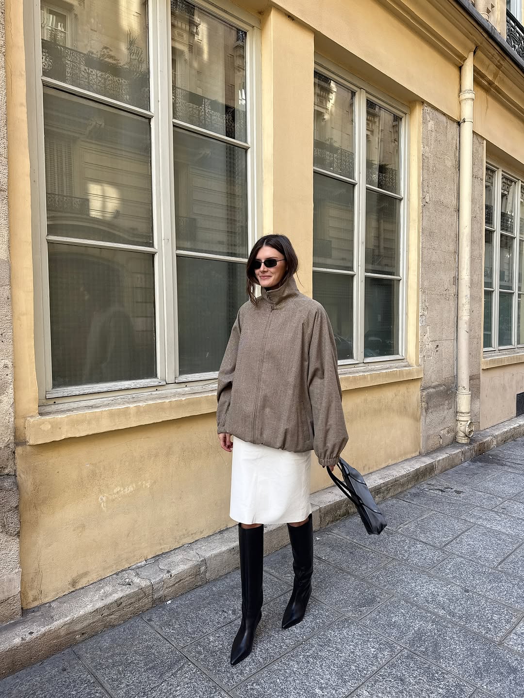 Woman wearing fall boots with skirt outfit 2025.