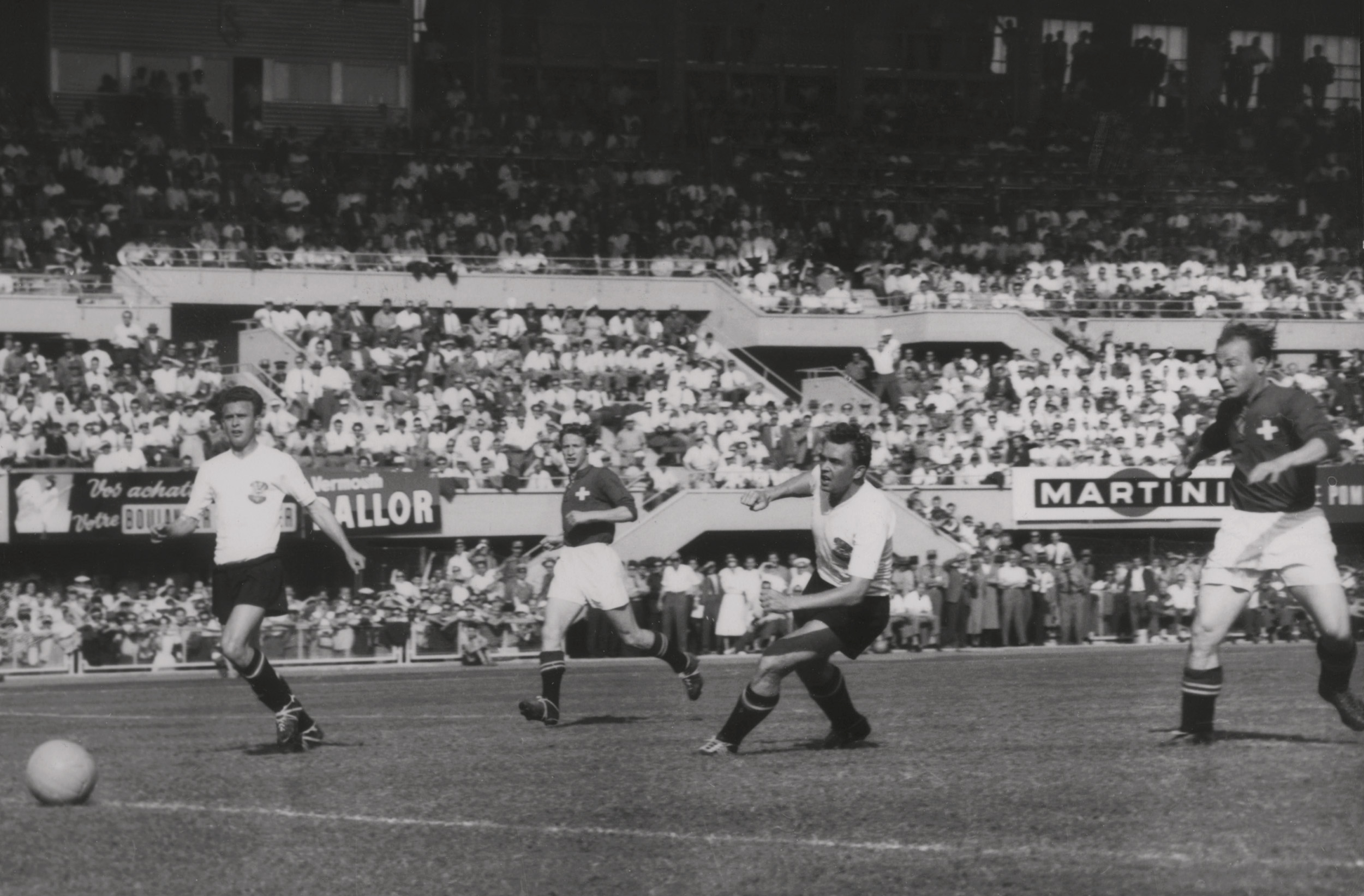 LAUSANNE, SUÍÇA - 26 DE JUNHO: O atacante suíço Josef Hugi II (R) marca um gol enquanto o companheiro de equipe Charles Antenen (C), os defensores austríacos Leopold Barschandt (L) e Gerhard Hanappi (2º R) observam.