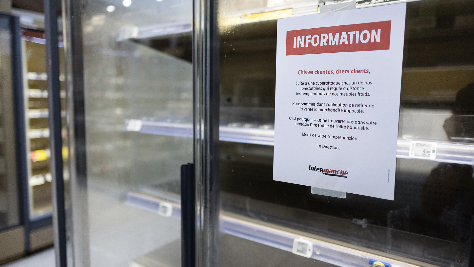 This photograph shows a customer notice displayed on empty fresh-food refrigerators at an Intermarche supermarket in Nevez, western France, on October 12, 2026, following a cyberattack affecting the French supermarket chains Intermarch&eacute; and Cooperative U that caused their refrigerators to defrost. (Photo by Fred TANNEAU / AFP via Getty Images)