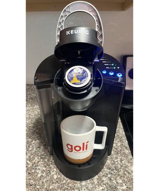 Inserting a Keurig K-cup into the Keurig K-Classic coffee maker machine