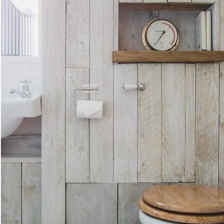 bathroom with wooden wall and clock