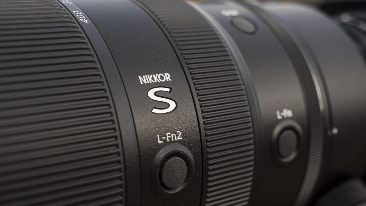 A Nikon Z telephoto lens on a wooden table