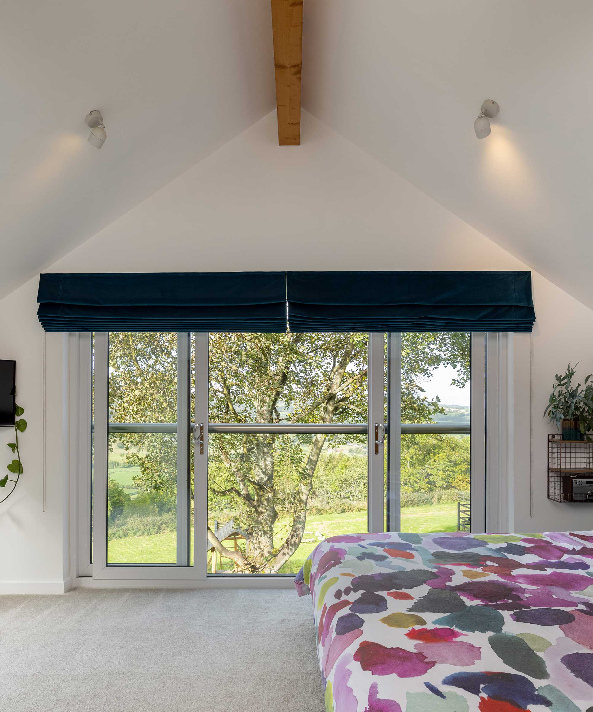 Bedroom with high ceilings, a Juliet balcony and exposed beams