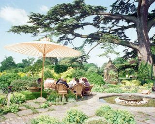 the gardens at highgrove house with the royal family sitting around a table