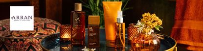 arran logo top left with a wide image of arran products in autumn orange