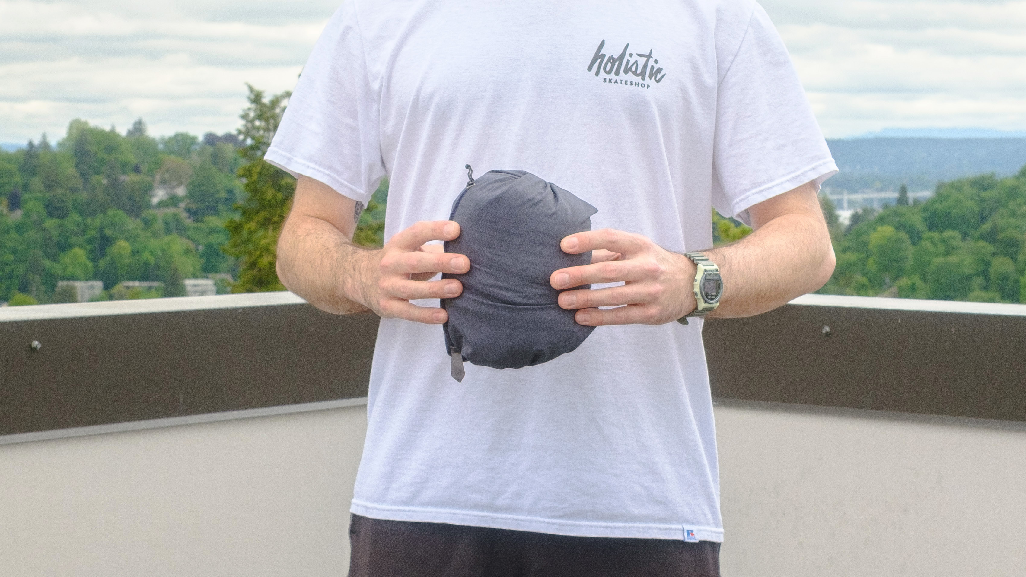 Senior writer Dan Bracaglia wearing the Patagonia Nano-Air Ultralight in grey/blue on the roof of his home in Seattle, Washington with trees and overcast skies in the distance
