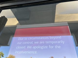 A sign seen outside of a Bank of America location saying it is temporarily closed due to the outage