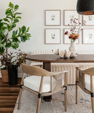 coastal scandi style dining room with a neutral ribbed banquette seat with dark wooden table and light wood woven dining chairs and a large shell on the table