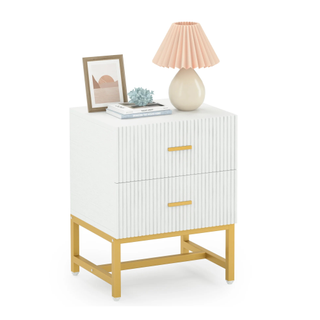 A white fluted nightstand with two drawers and gold hardware