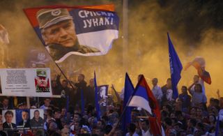 Serb ultra-nationalists wave flags showing Mladic at a rally in 2011