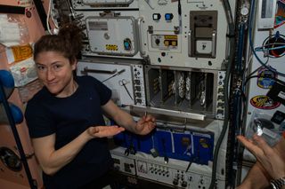 NASA astronaut Christina Koch displays the pizza cooking in an oven onboard the International Space Station.